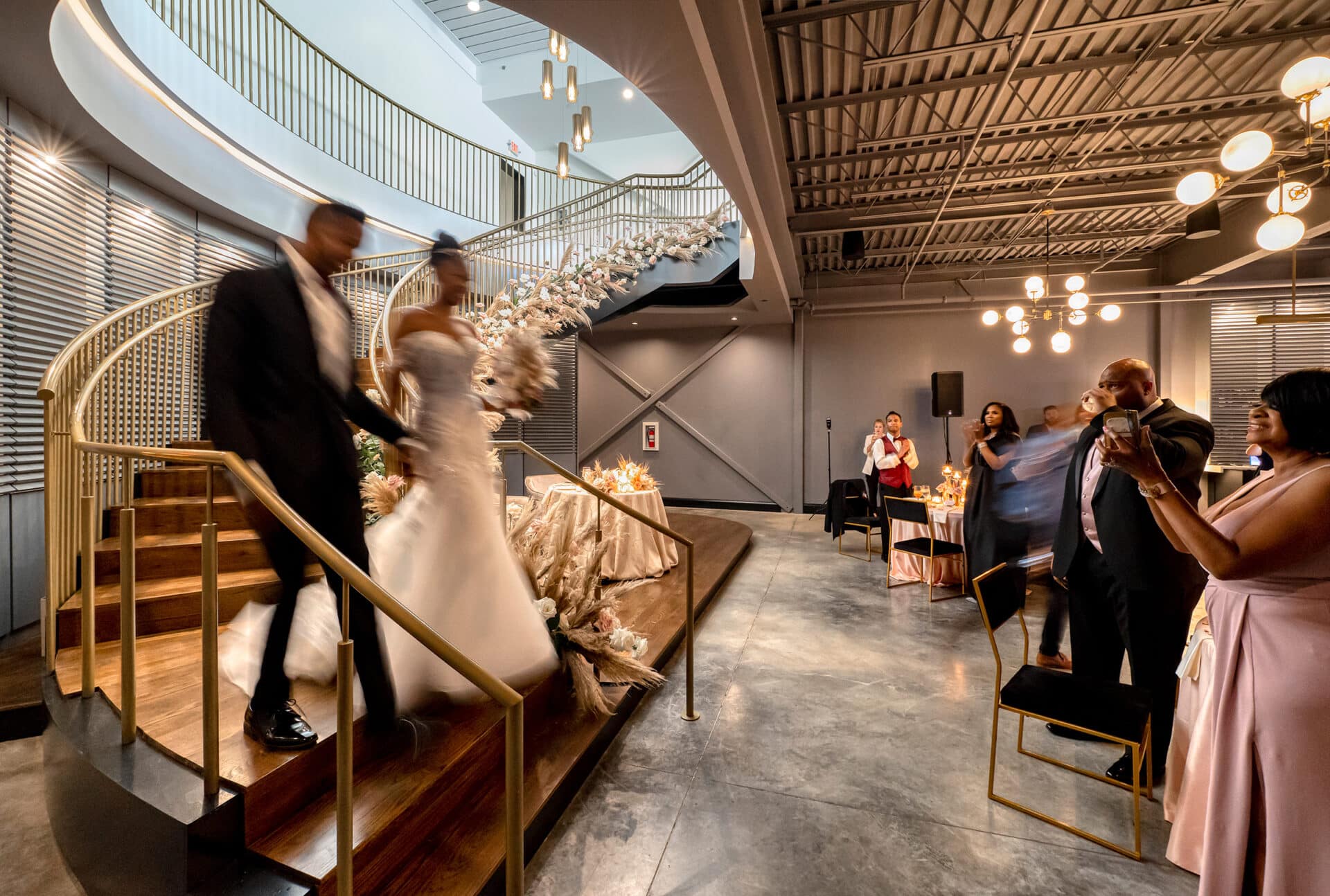Bride and groom walking down Dogwood staircase designed by Trivers Architectural Firm